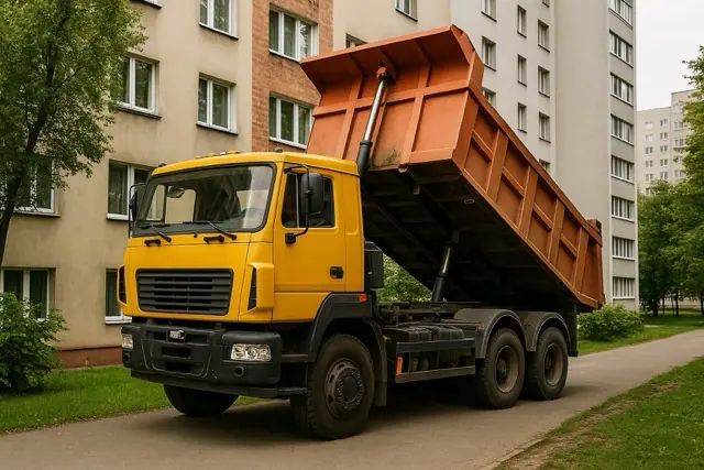Самосвал работает во дворе жилого дома или в узком проезде